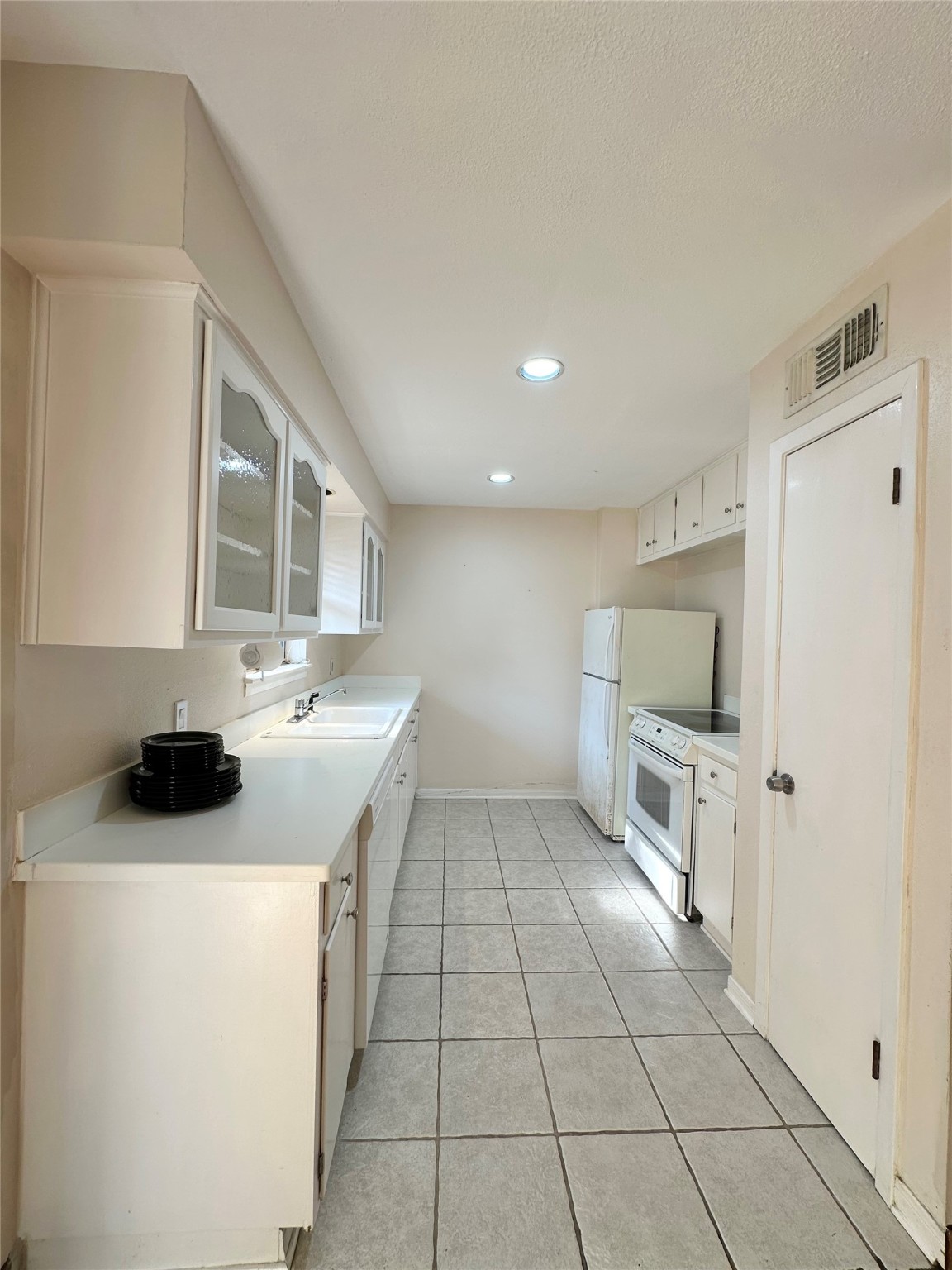 8245 Kingsbrook Road, Unit 236 Houston, TX 77024 - Photo 7 of 14 a kitchen with a sink a stove and cabinets