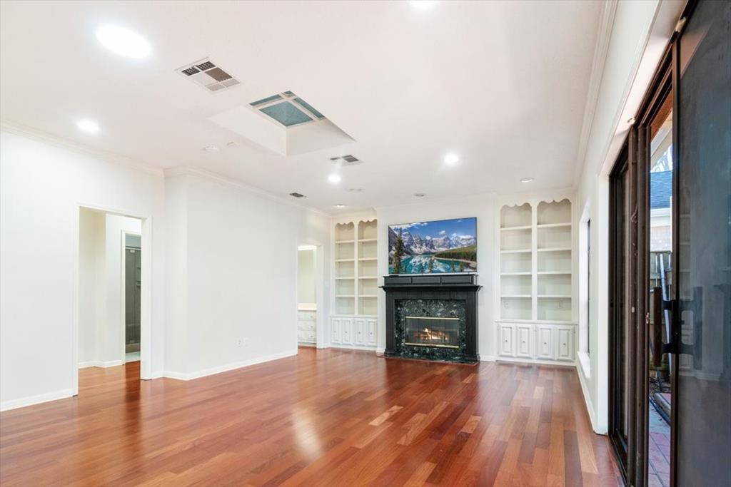 3410 Timbermill Road Waco, TX 76710 - Photo 15 of 32 an empty room with wooden floor fireplace and windows