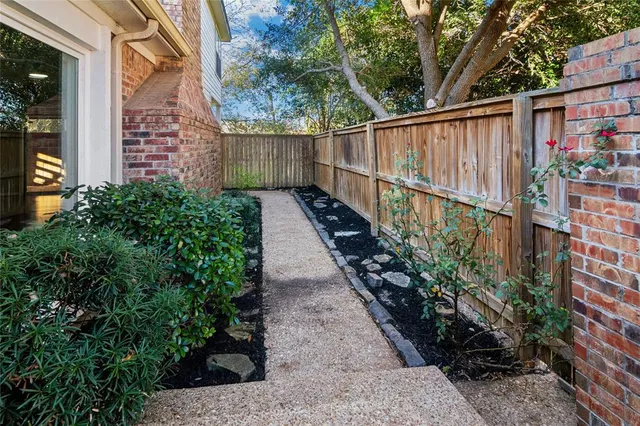 a view of a pathway with a flower garden