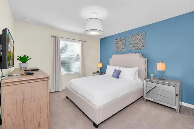 a bedroom with a large bed and a chandelier