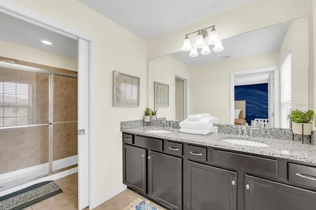 a bathroom with a granite countertop sink a large mirror and a shower