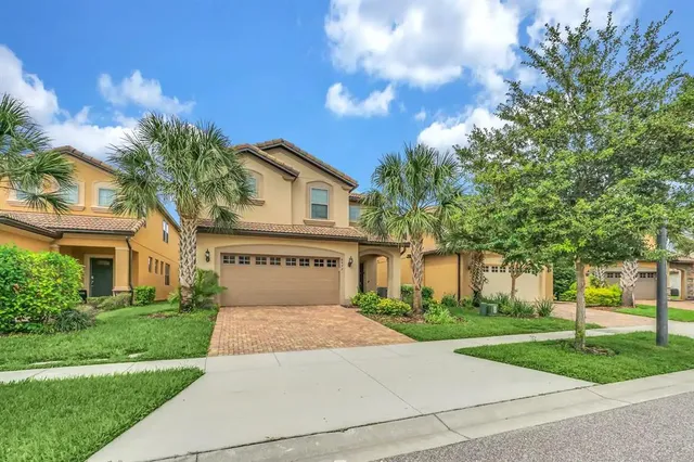 a front view of a house with a yard and trees