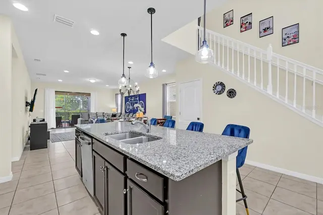 a kitchen with a sink a kitchen island with stainless steel appliances