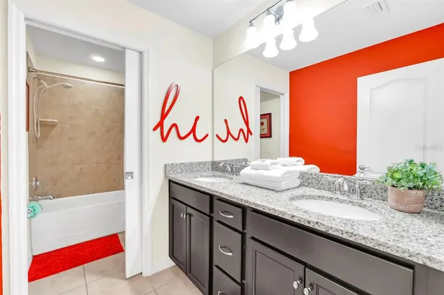 a bathroom with a granite countertop sink a mirror and shower