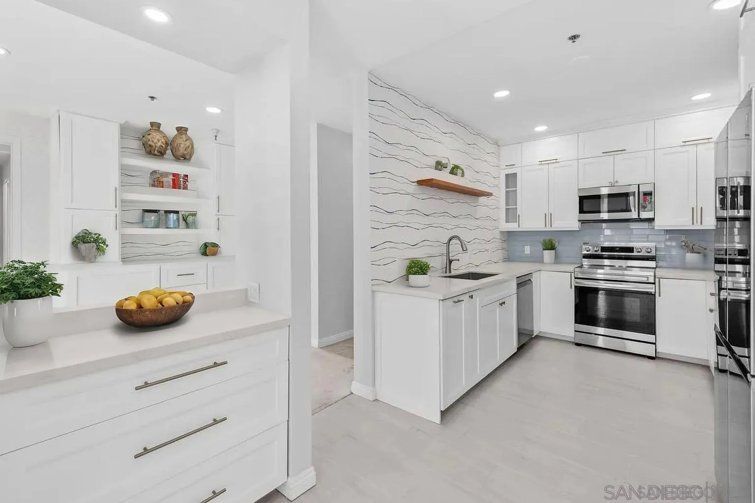 5845 Friars Road, Unit 1201 San Diego, CA 92110 - Photo 4 of 24 a kitchen with stainless steel appliances and white cabinets