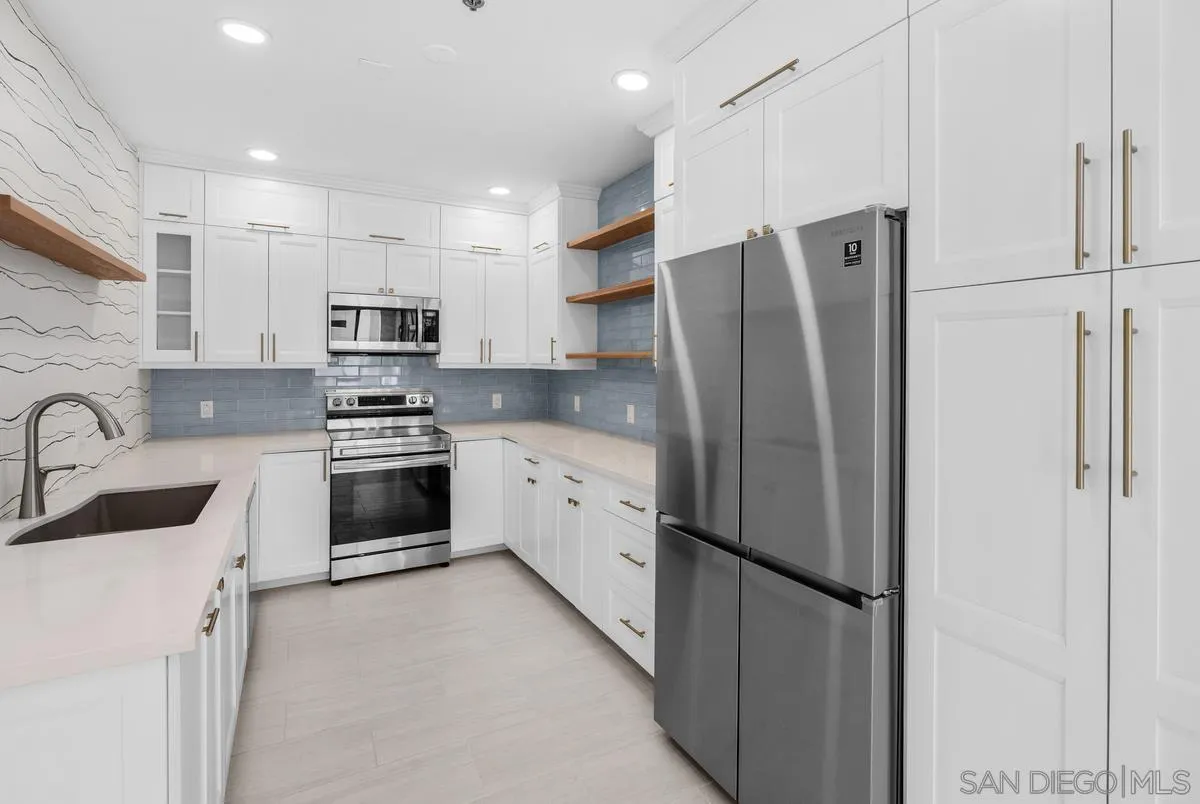 5845 Friars Road, Unit 1201 San Diego, CA 92110 - Photo 6 of 24 a kitchen with stainless steel appliances a refrigerator sink and white cabinets