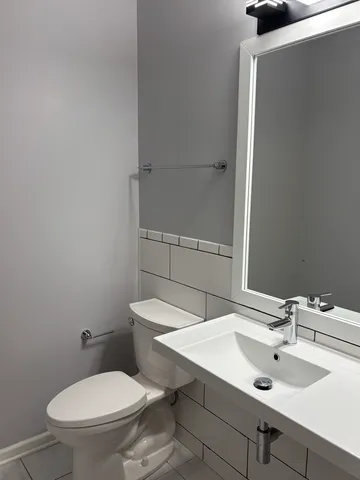 a bathroom with a sink a toilet and mirror