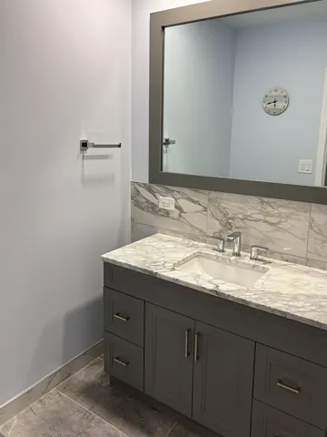 a bathroom with a granite countertop sink and a mirror