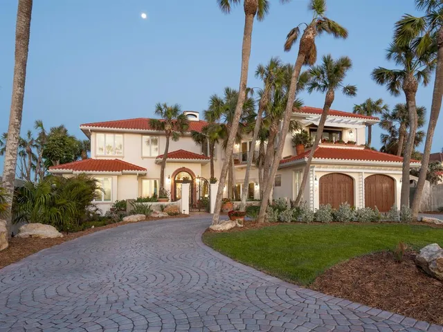 a view of a swimming pool with a yard and palm trees
