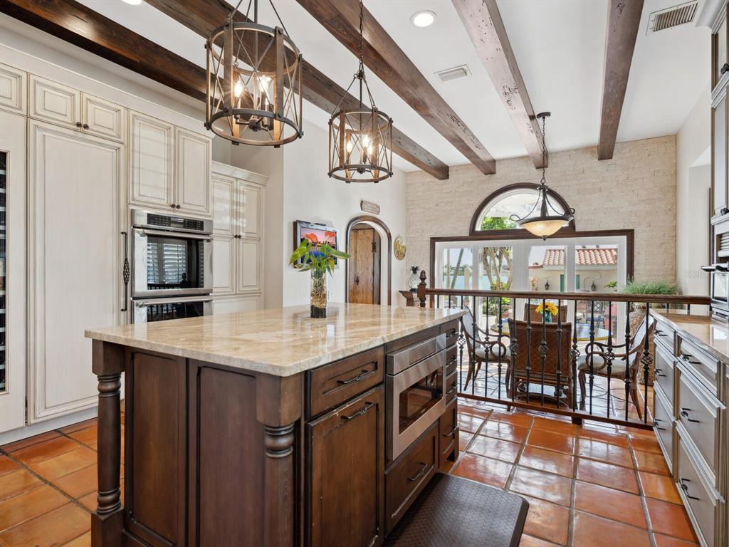 2110 Casey Key Road Nokomis, FL 34275 - Photo 19 of 75 a kitchen with stainless steel appliances granite countertop a sink a stove top oven a chimney and cabinets