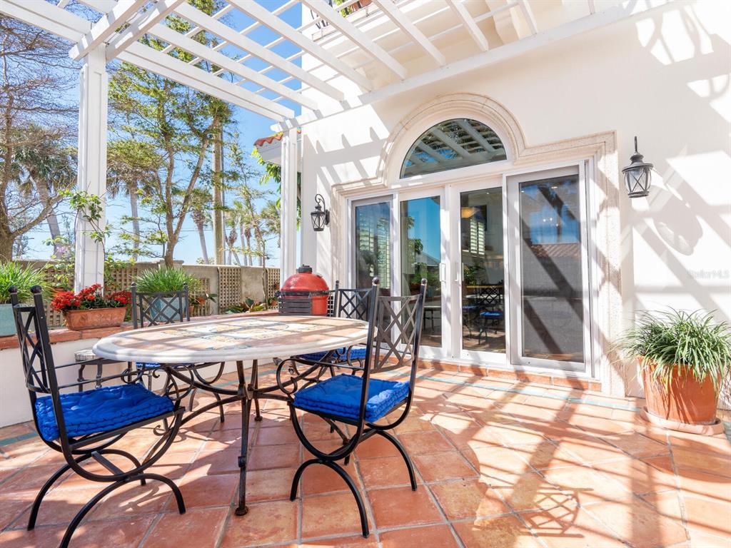 2110 Casey Key Road Nokomis, FL 34275 - Photo 22 of 75 a view of a patio with table and chairs with wooden floor and plants