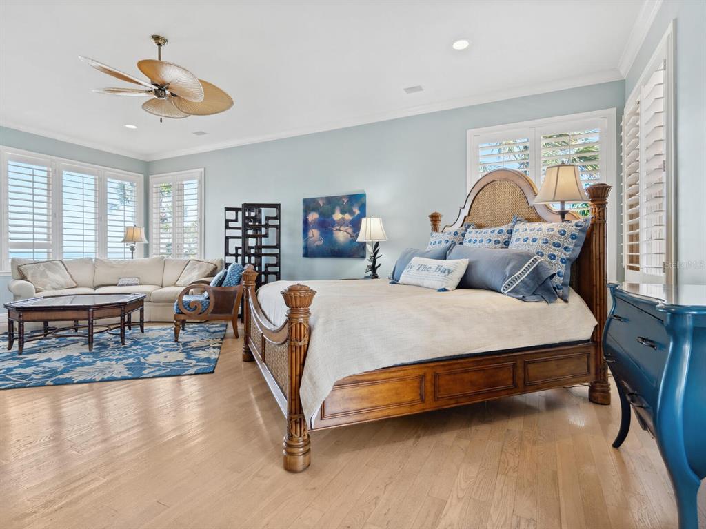 2110 Casey Key Road Nokomis, FL 34275 - Photo 27 of 75 a spacious bedroom with a bed a couch and a chandelier