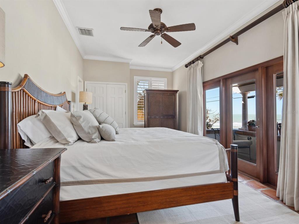 2110 Casey Key Road Nokomis, FL 34275 - Photo 32 of 75 a bedroom with a bed and a chandelier