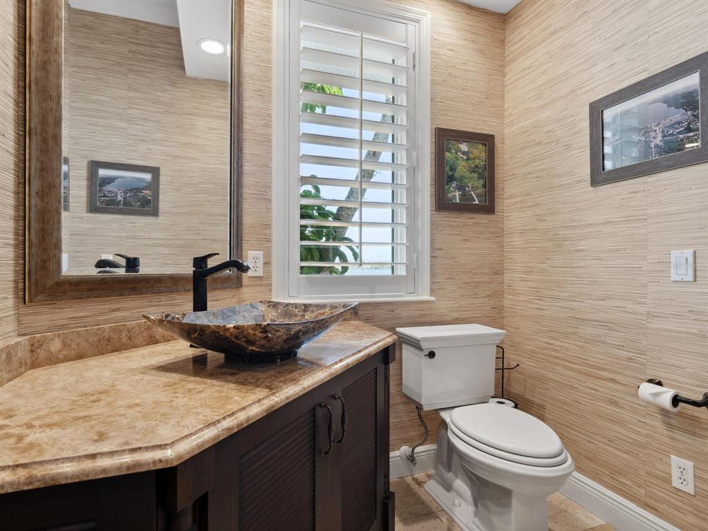 2110 Casey Key Road Nokomis, FL 34275 - Photo 39 of 75 a bathroom with a granite countertop toilet a sink and a window