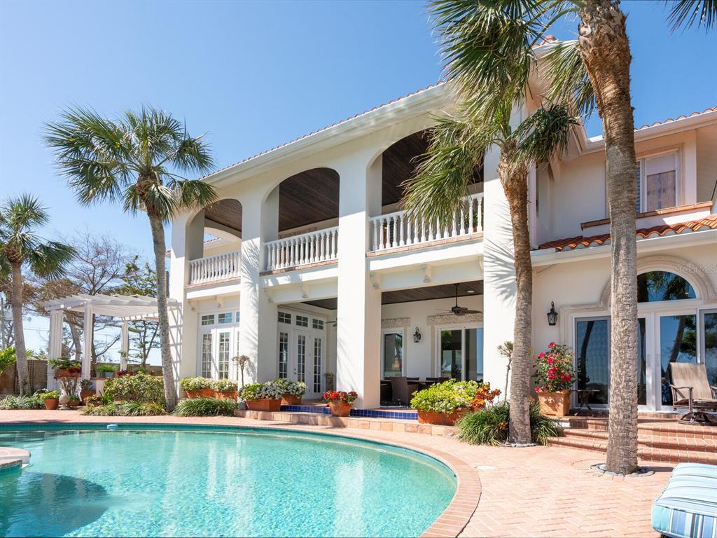 2110 Casey Key Road Nokomis, FL 34275 - Photo 55 of 75 a patio with a table and chairs and a swimming pool