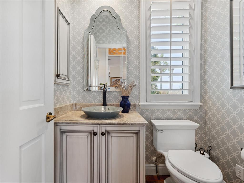 2110 Casey Key Road Nokomis, FL 34275 - Photo 65 of 75 a bathroom with a granite countertop sink a toilet and a mirror