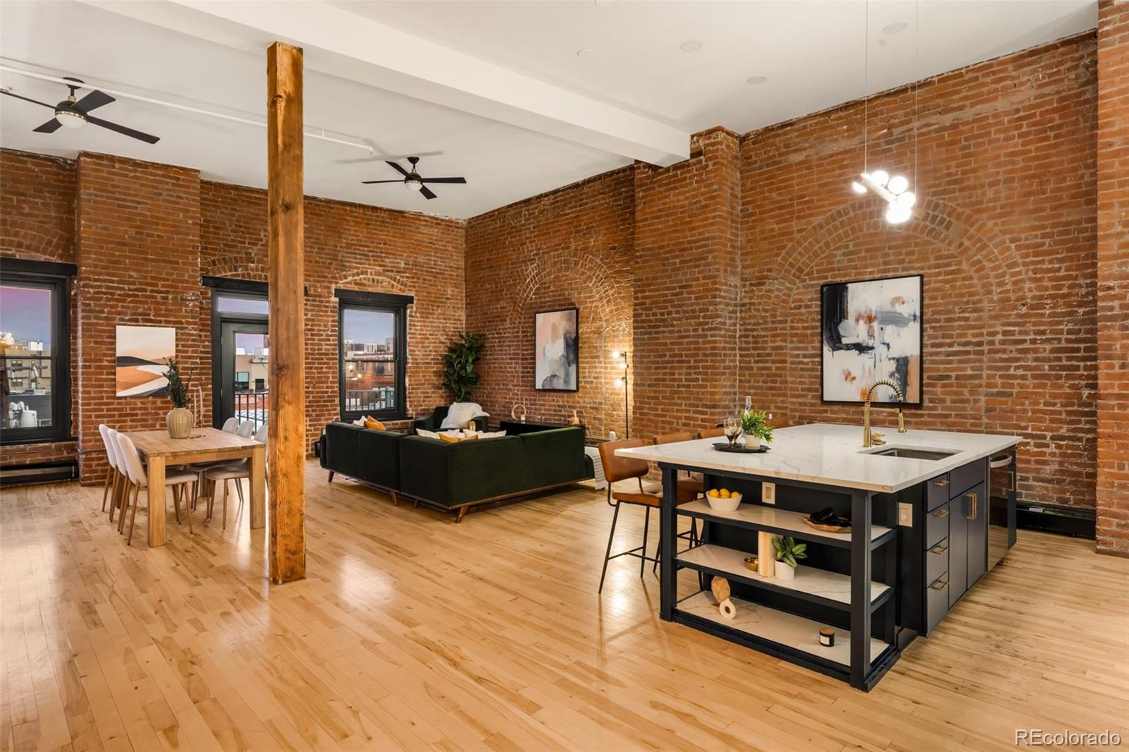 a living room with furniture a table and wooden floor