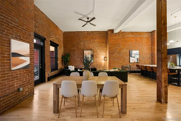 a dining room with furniture a chandelier and wooden floor