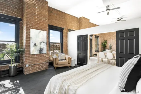 a bedroom with furniture and large windows