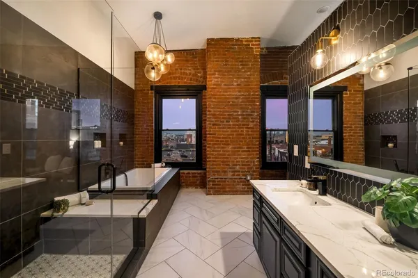 a bathroom with a granite countertop sink a toilet a mirror and bathtub