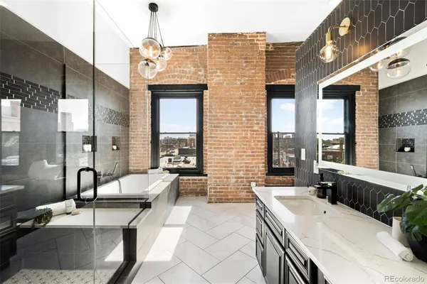a spacious bathroom with a granite countertop double vanity sink a bathtub and window