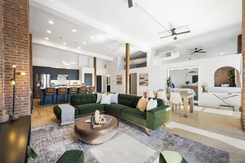 a living room with furniture and a view of kitchen
