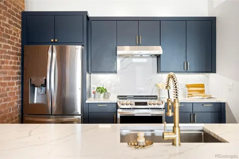 a kitchen with stainless steel appliances kitchen island granite countertop a refrigerator and a stove