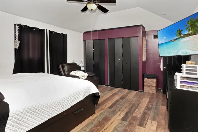 a bedroom with a bed and a flat tv screen