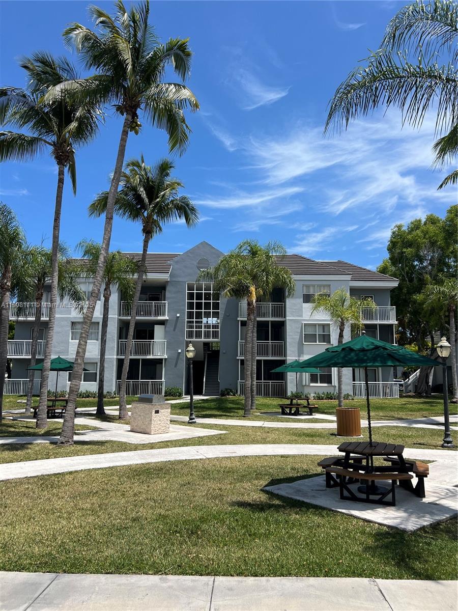 8590 Southwest 212th Street, Unit 211 Cutler Bay, FL 33189 - Photo 20 of 22 a view of a building with a swimming pool