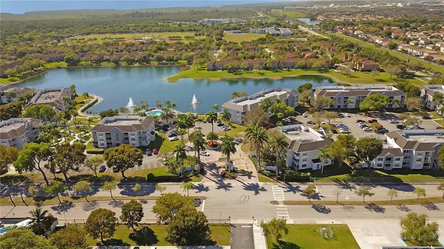 an aerial view of ocean and residential houses with outdoor space