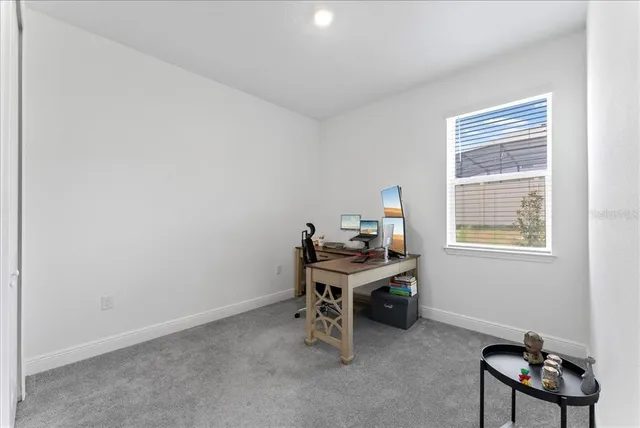 a view of a workspace with furniture and a window
