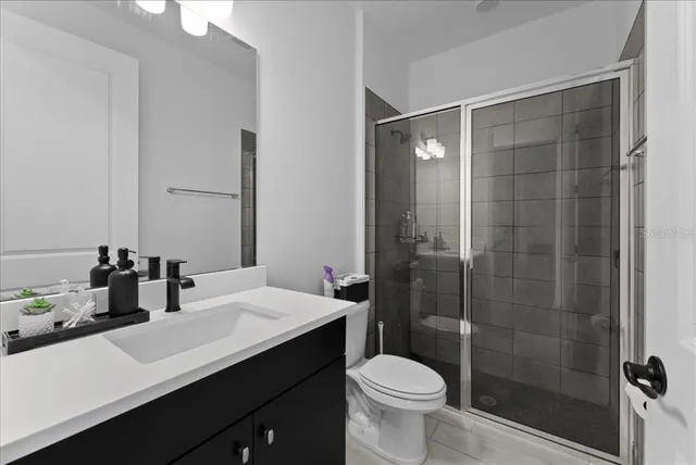 a bathroom with a sink a toilet a mirror and shower