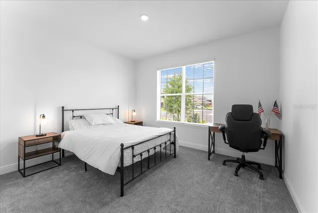 a bedroom with a bed and a chair in it