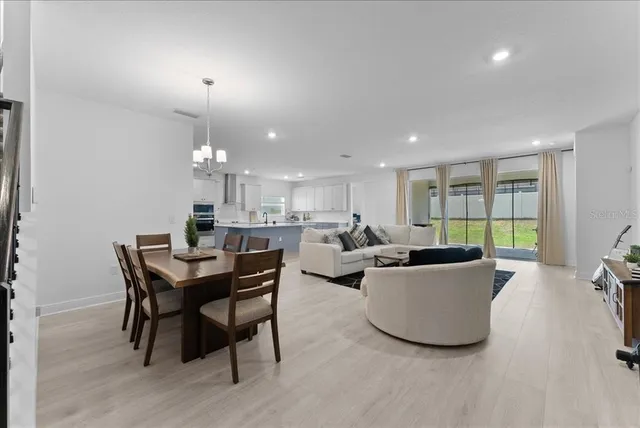 a living room with furniture a chandelier and a wooden floor