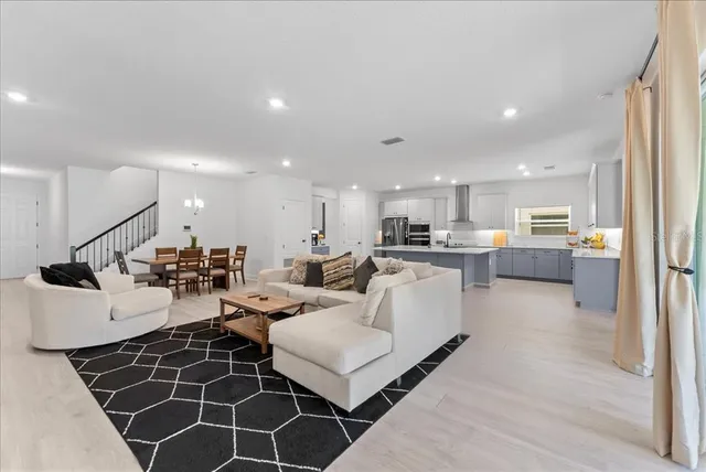 a living room with lots of furniture and kitchen view