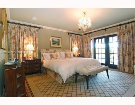 4511 Lake Road Miami, FL 33137 - Photo 13 of 14 a spacious bedroom with a bed a dresser and wooden floor