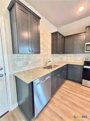 a kitchen with stainless steel appliances granite countertop a sink stove and refrigerator