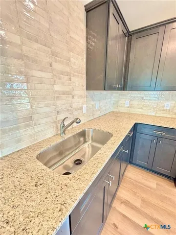 a bathroom with a granite countertop sink and a bathtub