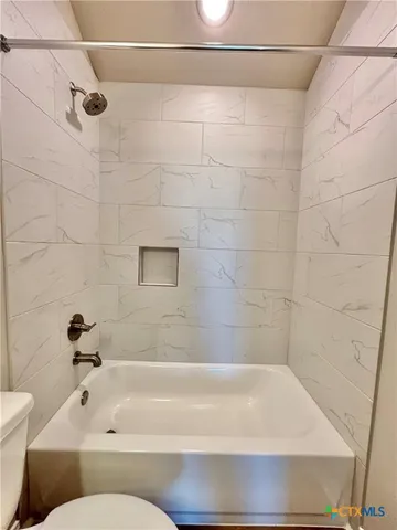 a bathroom with a bathtub and a toilet