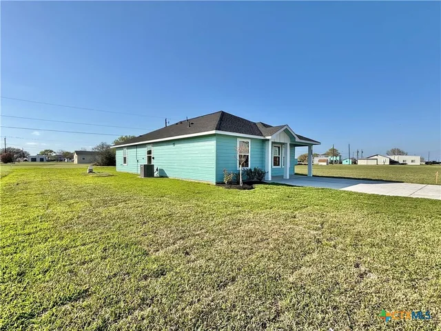 a front view of a house with a garden and lake view