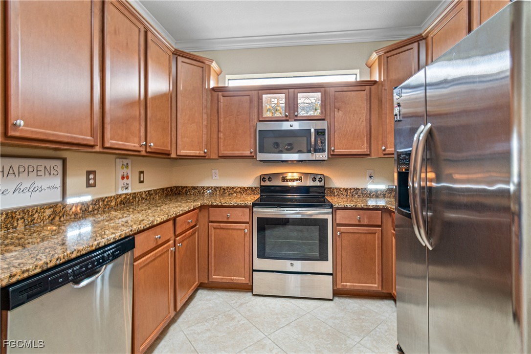 9138 Water Tupelo Road Fort Myers, FL 33912 - Photo 11 of 28 a kitchen with stainless steel appliances granite countertop a refrigerator a stove a sink and a microwave