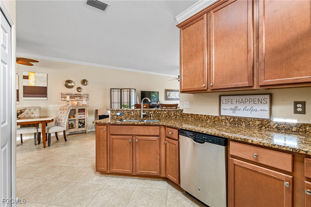 9138 Water Tupelo Road Fort Myers, FL 33912 - Photo 10 of 28 a kitchen with stainless steel appliances granite countertop a lot of counter space and a sink