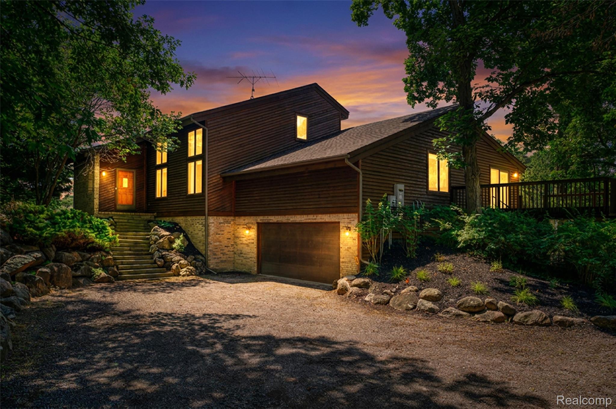 Multi-level residence featuring wood-panel siding and stone veneer accents