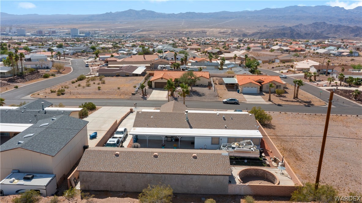 784 Pegasus Ranch Road Bullhead City, AZ 86429 - Photo 96 of 100 Desert landscape featuring a single-story residence with an attached covered patio, an additional detached building, and a circular raised brick planter