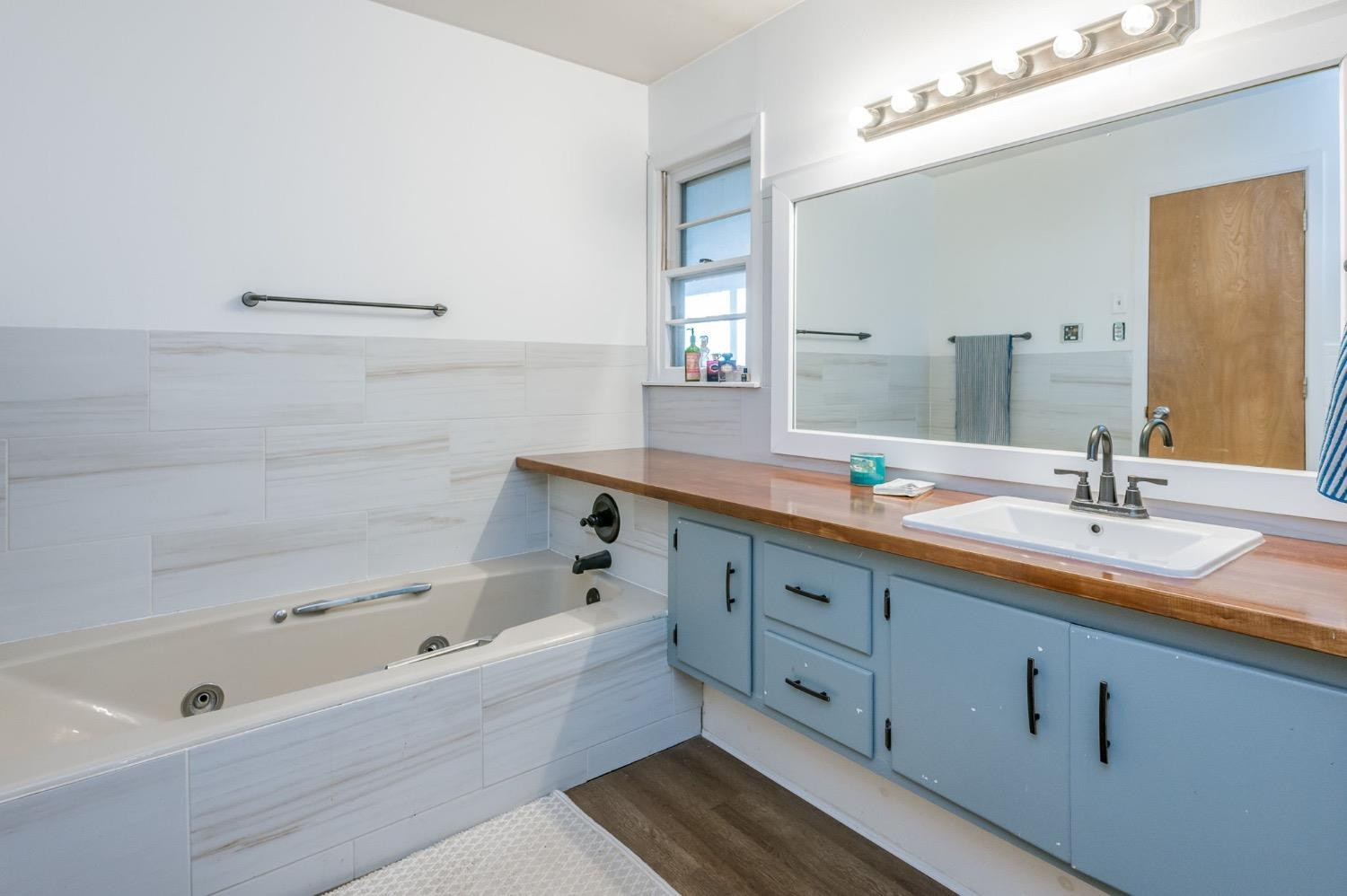 1401 County Road Z Plainview, TX 79072 - Photo 19 of 41 a bathroom with a tub double sink and mirror