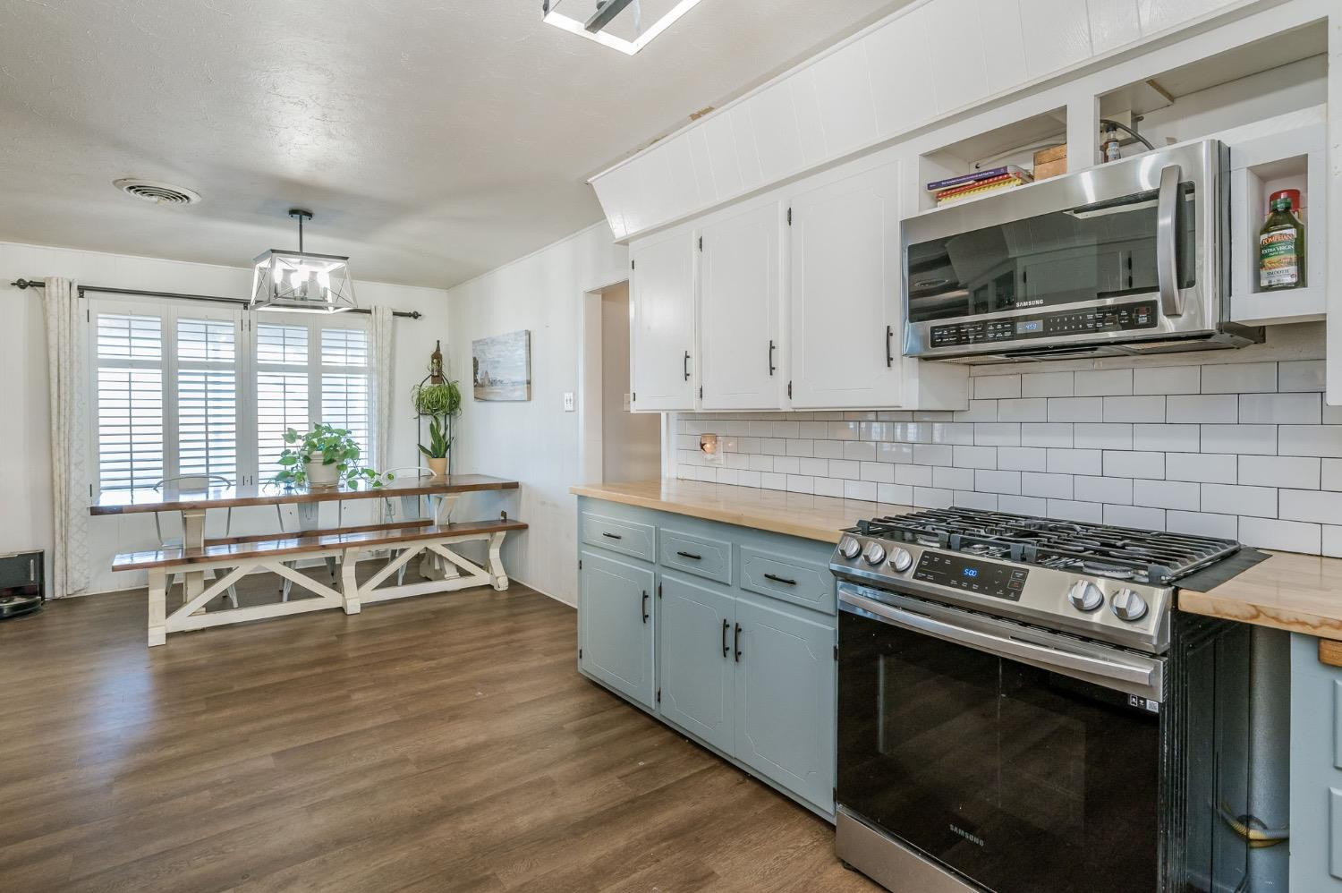 1401 County Road Z Plainview, TX 79072 - Photo 7 of 41 a kitchen with stainless steel appliances a stove a sink cabinets and a wooden floor