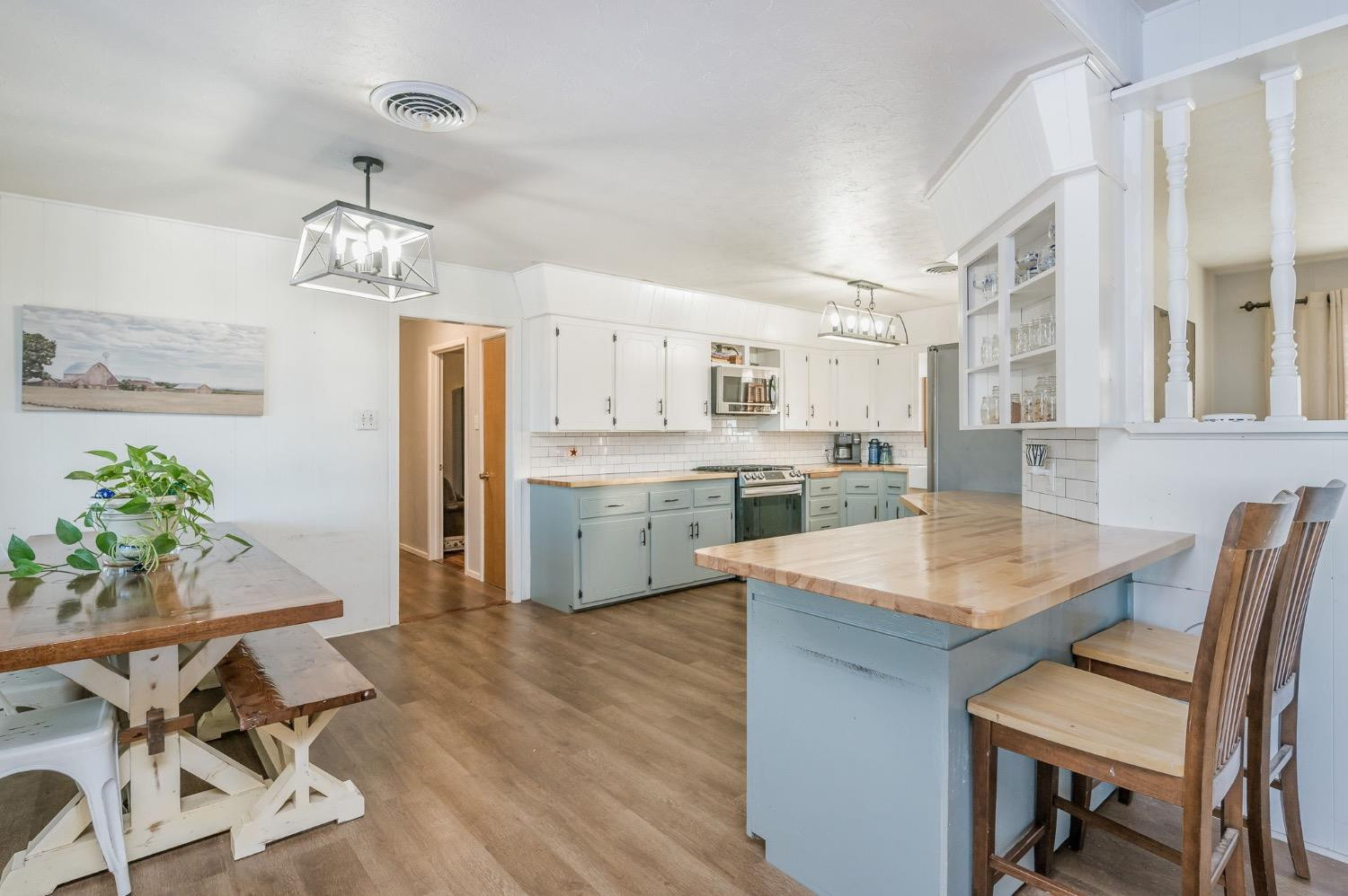 1401 County Road Z Plainview, TX 79072 - Photo 10 of 41 a open dining room with kitchen island stainless steel appliances furniture a chandelier and kitchen view
