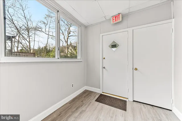 a view of a hallway with wooden floor and closet