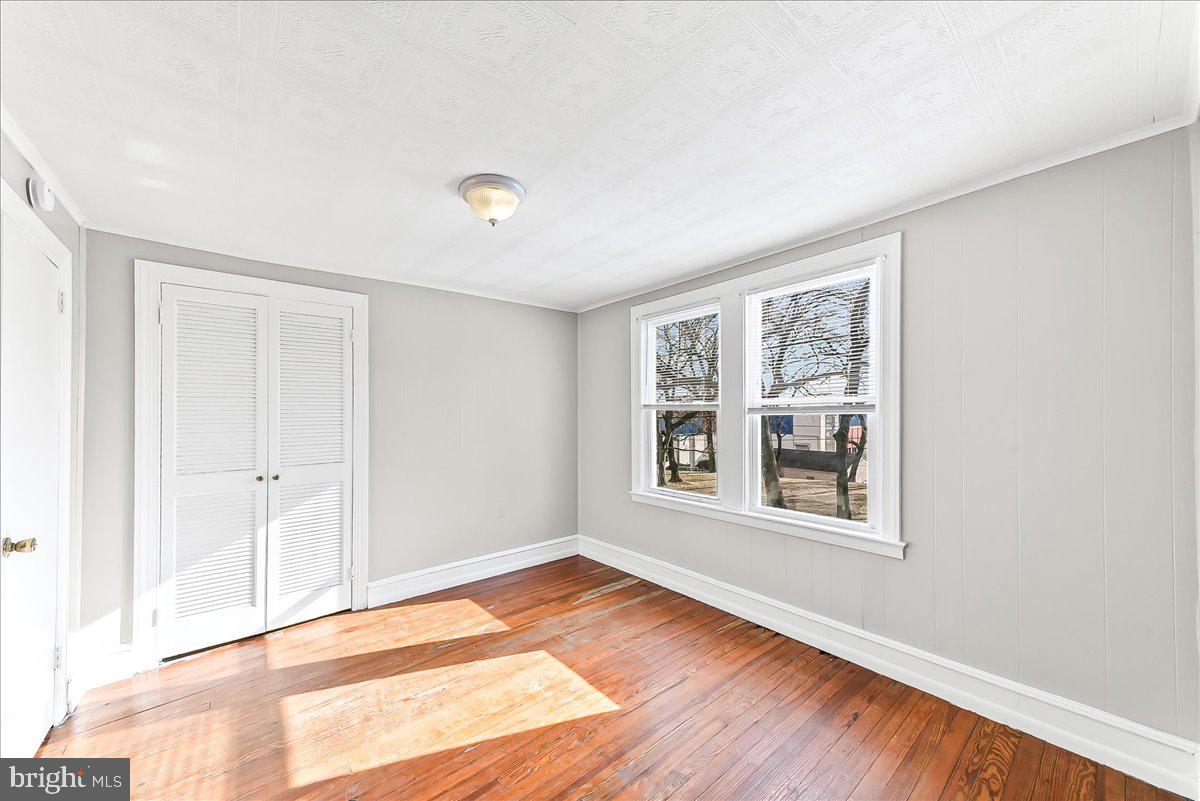 1024 East 18th Street Chester, PA 19013 - Photo 17 of 31 an empty room with wooden floor and windows