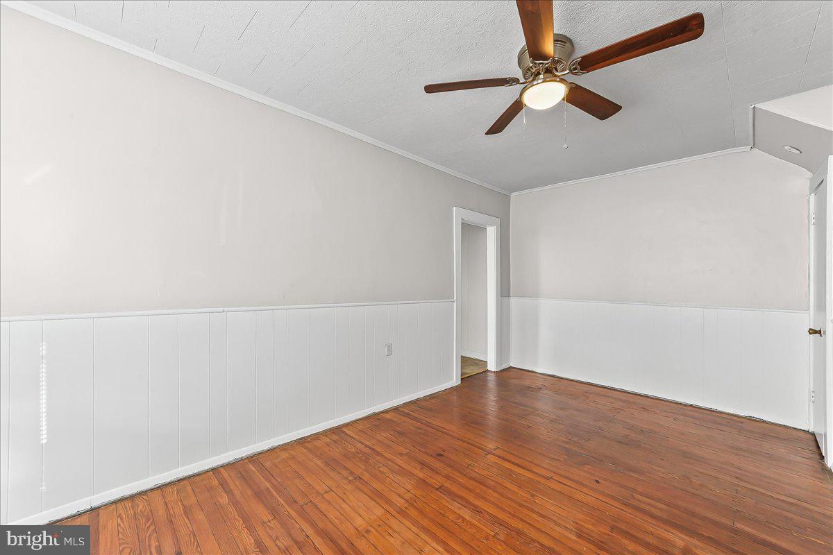 1024 East 18th Street Chester, PA 19013 - Photo 9 of 31 an empty room with wooden floor fan and windows